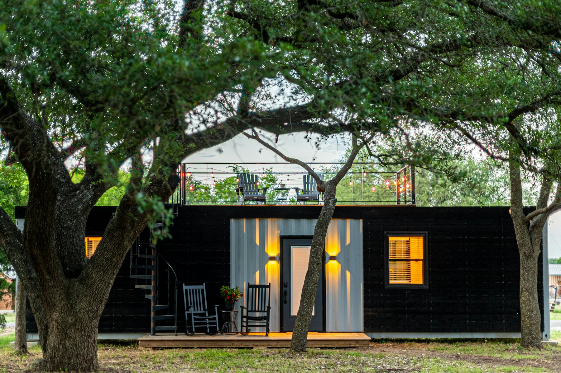Container farmhouse retreat set among mature trees